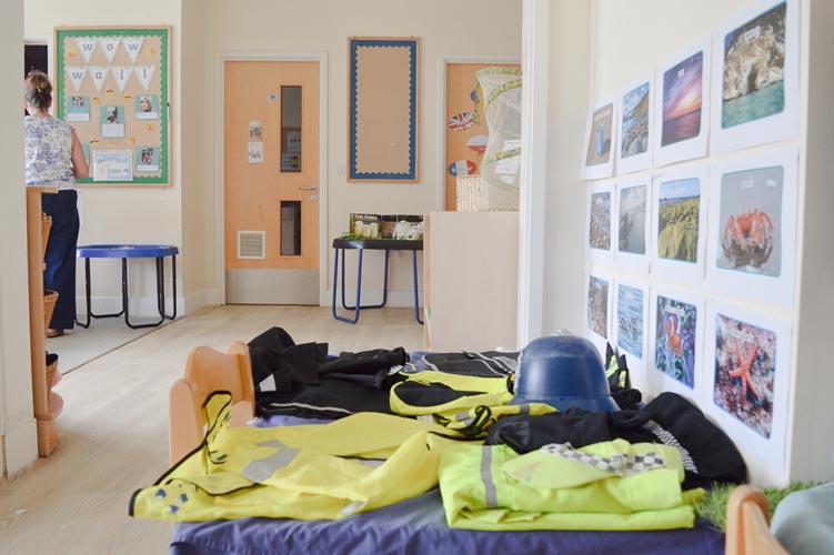 a nursery room with a focus on a table with children's dress up police uniforms