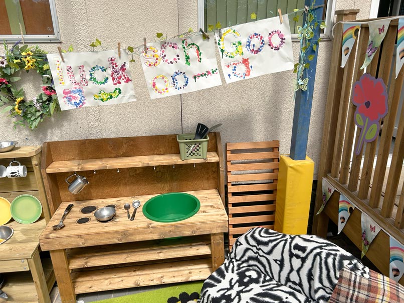 an outdoor children's play area with colourful signs and kitchen utensils