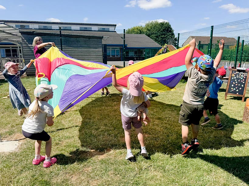 children playing outside around a colourful parachute